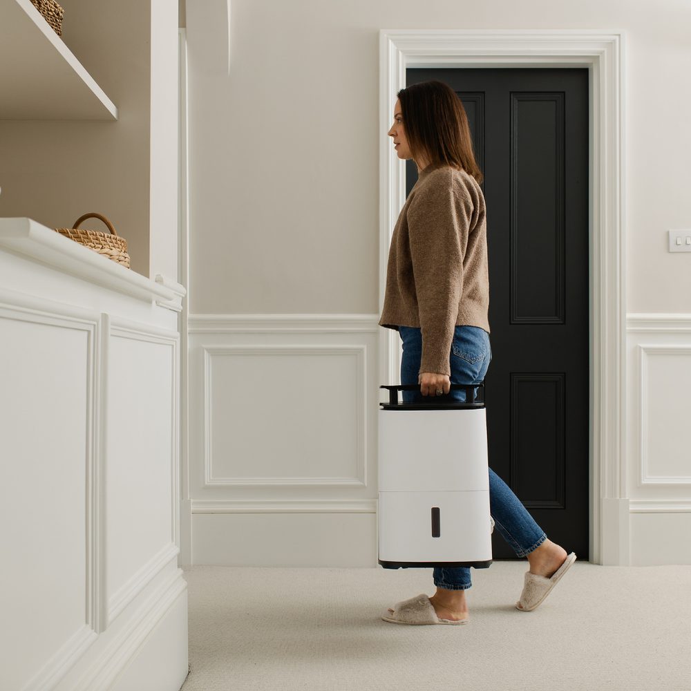 Γυναίκα μεταφέρει τον Meaco Arete Two 12L — Μόλις 10,9 κιλά, εύκολος στη μεταφορά